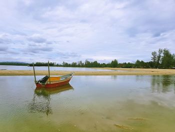 Boat moored on sea against sky