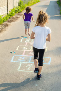 Rear view of boy walking on road