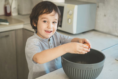 A little boy is cooking in the kitchen.