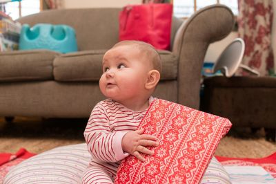 Cute boy sitting on sofa at home