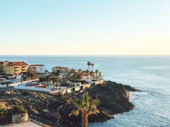 High angle view of townscape by sea against clear sky