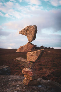 Stack of rocks on land against sky