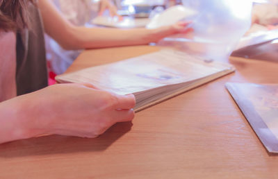 Midsection of woman using smart phone on table