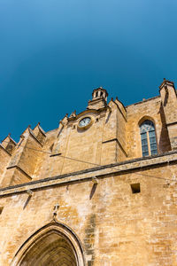 Low angle view of old building against clear blue sky