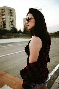 Side view of young woman standing outdoors