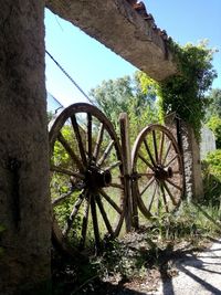 Low angle view of rusty wheel against sky