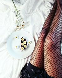 Low section of woman standing on bed