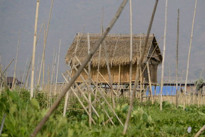 Stilt house on field against sky
