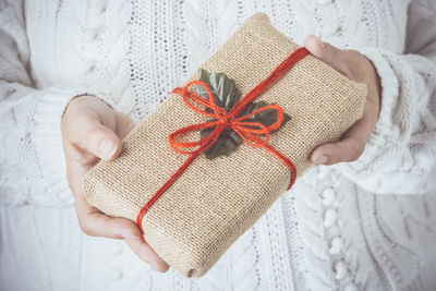 Midsection of woman holding of christmas present