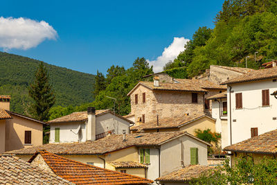 Houses and buildings in town against sky