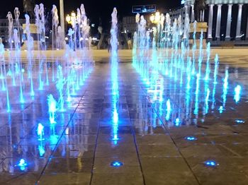 Reflection of illuminated lights in puddle