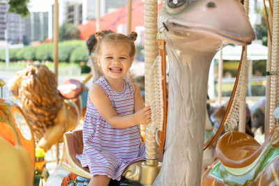 Happy girl enjoying on carousel