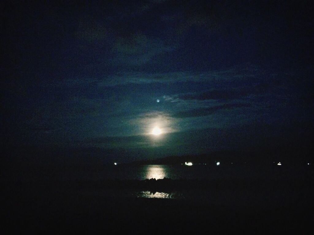 night, illuminated, scenics, sky, tranquility, dark, tranquil scene, beauty in nature, sea, water, moon, nature, idyllic, copy space, horizon over water, reflection, no people, dusk, outdoors, waterfront