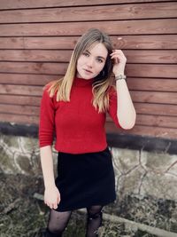 Young woman standing against wall