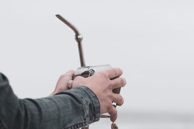 Close-up of man holding hands against white background