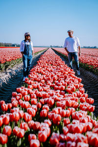 Full length of man with red berries on field against sky