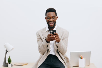 Portrait of senior man sitting against white background