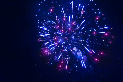Low angle view of firework display at night