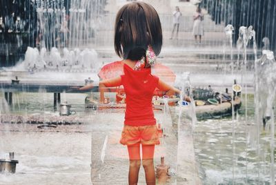 Rear view of woman standing in water