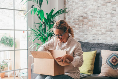 Young woman using digital tablet while sitting at home