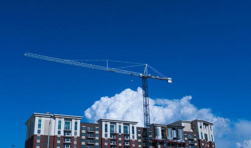 Low angle view of crane against sky