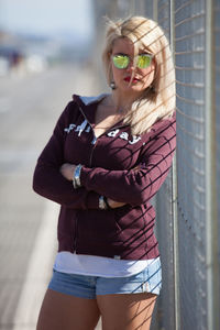 Portrait of young woman wearing sunglasses standing outdoors