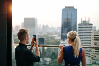 Woman photographing with city in background