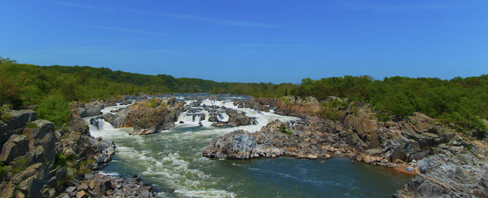 Scenic view of river amidst rocks against sky