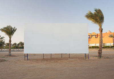 Blank billboard at beach against sky