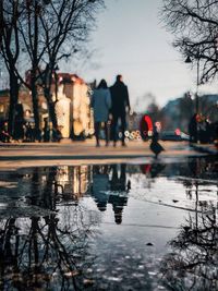 People on wet street in city