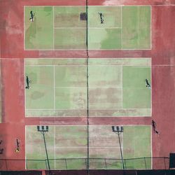 Directly above shot of players playing tennis while standing in court