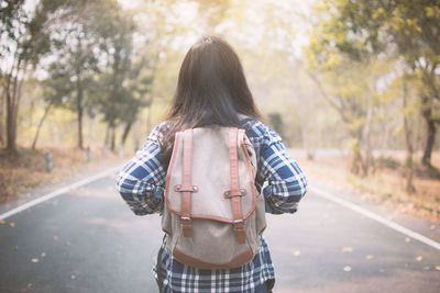 Rear view of man walking on road