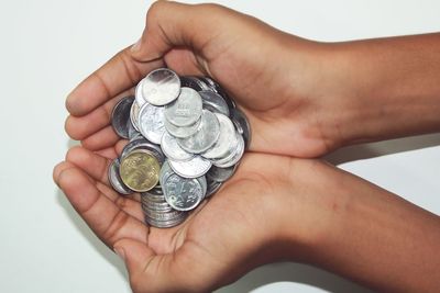 Cropped hands holding coins over table