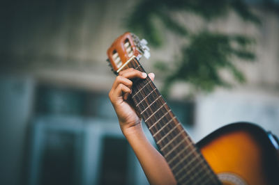 Close-up of person hand playing guitar