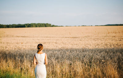 Rear view of bride standing on farm