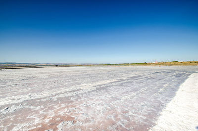 Scenic view of desert against clear blue sky