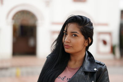 Portrait of woman standing against built structure