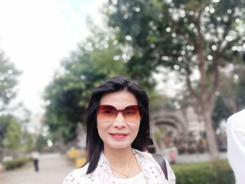 Portrait of mature woman wearing sunglasses in park