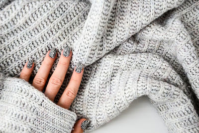 Hand in sweater with zebra animal printed nails. female manicure. glamorous beautiful manicure.