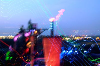 Digital composite image of illuminated amusement park at night