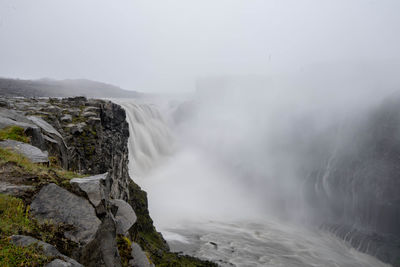 Scenic view of waterfall against mountains