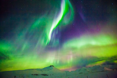 Scenic view of snowcapped mountains against sky at night