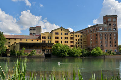 Buildings by lake against sky