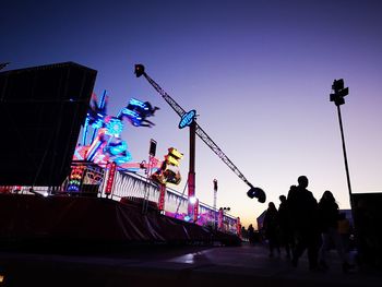 Low angle view of illuminated ferris wheel against sky