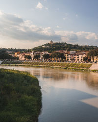 Scenic view of river by buildings against sky