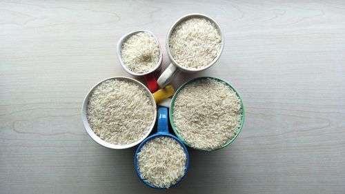 High angle view of rice in various cups on table