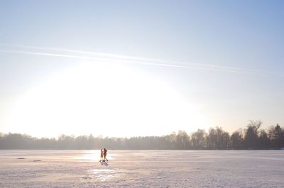 Woman walking on snow covered landscape