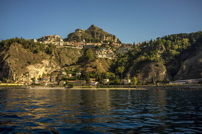 Scenic view of lake by buildings against clear sky