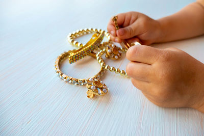 Childrens hands play with gold jewelry and bijouterie, on white. concept of womens happines