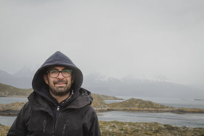 Portrait of young man standing against mountain